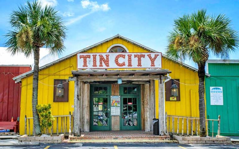 front exterior of yellow building with sign at tin city waterfront shops naples