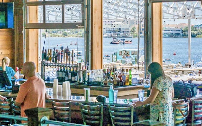 interior of bar with patrons and harbor view through windows at brotulas seafood house steamer destin