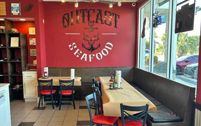 interior of diner area with shop windows and wall mural logo at outcast seafood miramar beach