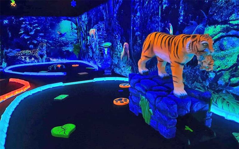 neon indoor putting area with tiger at rainforest black light golf arcade miramar beach