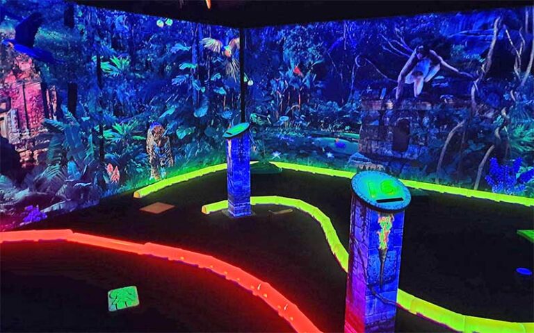 neon putting green with jungle setting at rainforest black light golf arcade miramar beach
