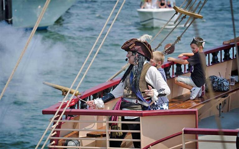 pirate captain firing cannon with kids on ship deck at buccaneer pirate cruise destin