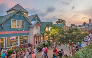 row of shops along walkway at twilight at harborwalk village destin