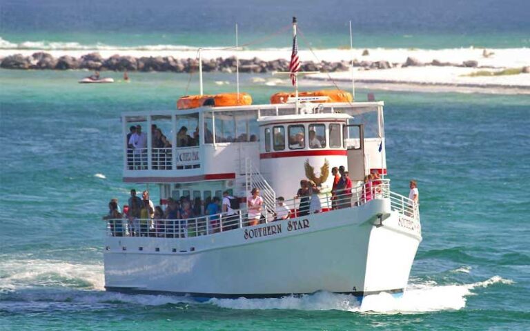 tour boat moving across bay with jetty at southern star dolphin cruise destin