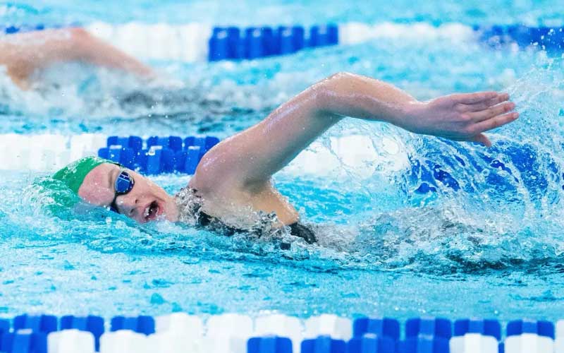 female swimmer competing in pool match for university of west florida