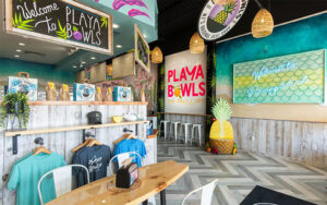 order counter with colorful signs and shirts at playa bowls dr phillips orlando