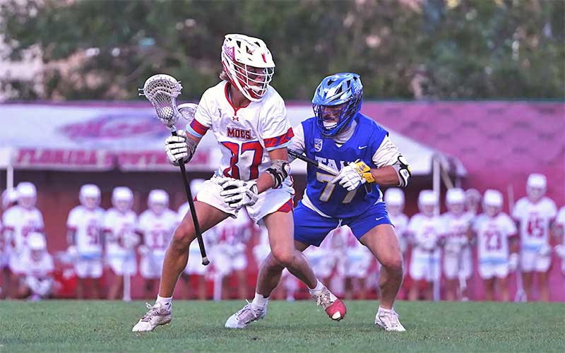 two lacrosse players running on field at florida southern game