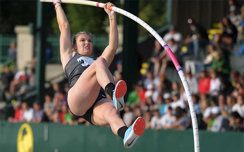 woman pole vaulter jumping at track and field event
