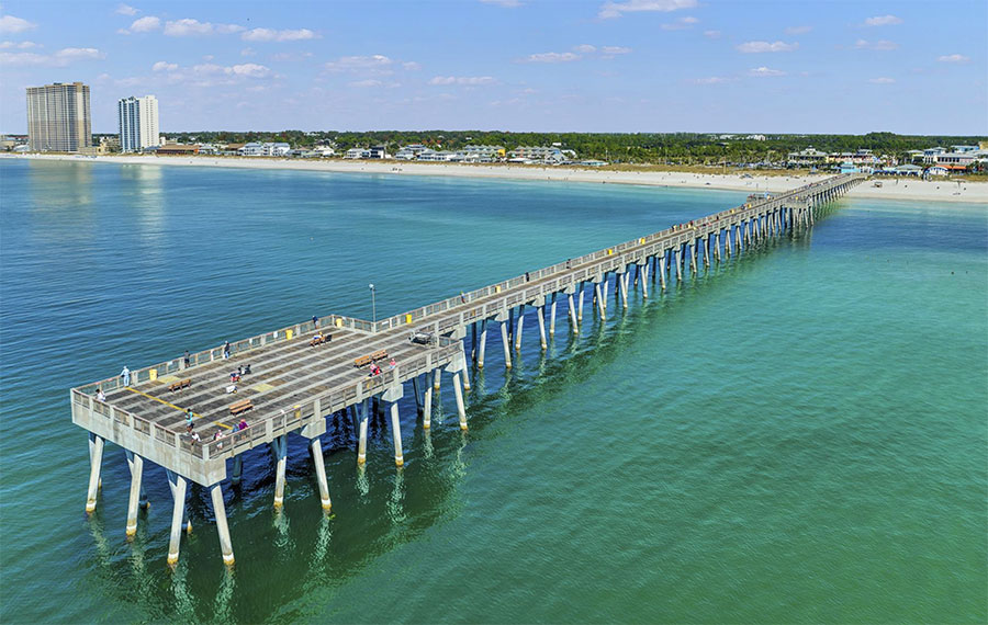 aerial view of fishing pier and beach over green water at russell fields pier panama city beach
