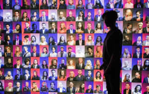 art installation wall mural with different headshots of people with silhouetted woman viewing at ai more than human frost museum