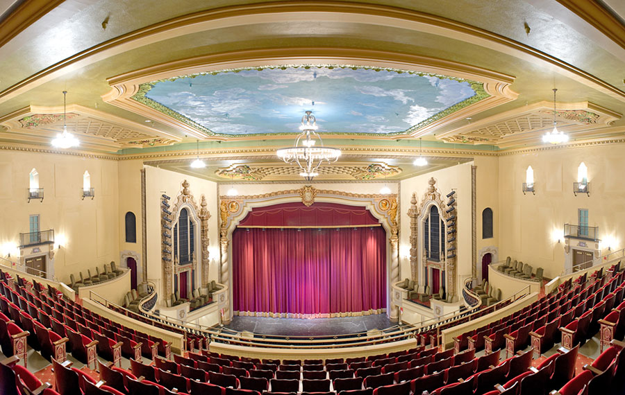 back row of theater seats and stage with red curtain at saenger theatre pensacola