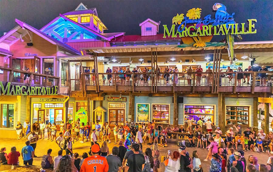 colorful night parade with band and crowd at margaritaville harborwalk village destin