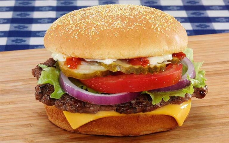 deluxe cheeseburger with the works on dining table cutting board at portillos orlando tampa
