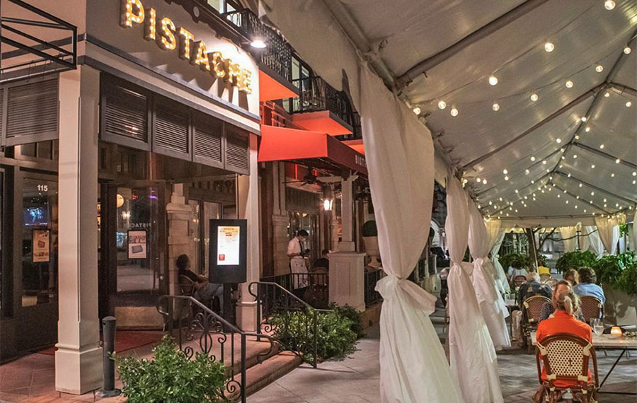 exterior restaurant with sign and tents over sidewalk cafe pistache french bistro west palm beach