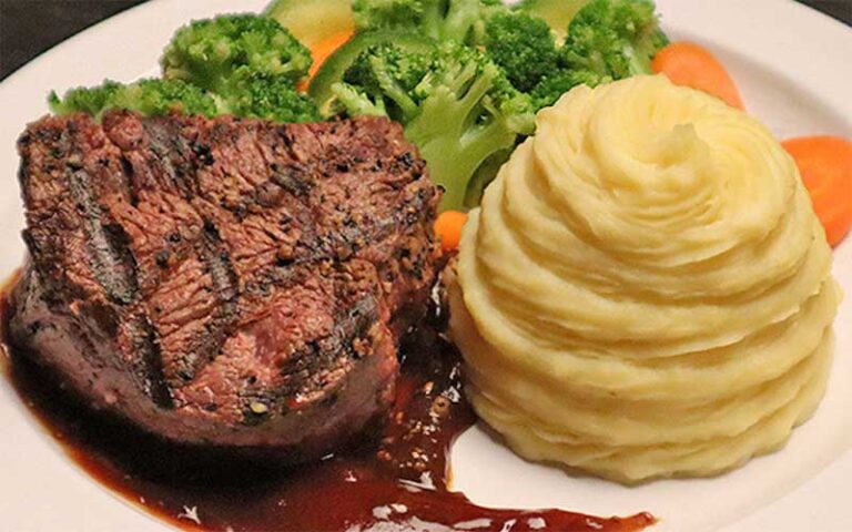 grilled steak with potatoes and broccoli at speakeasy murder teatro martini