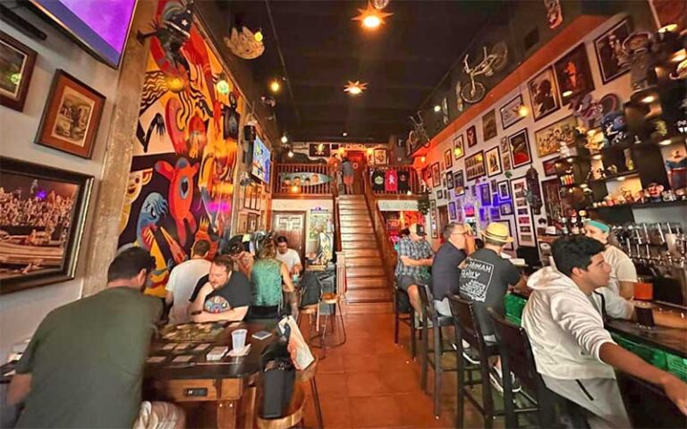 interior of two level bar with arcade games and eclectic decor at the retro room key west
