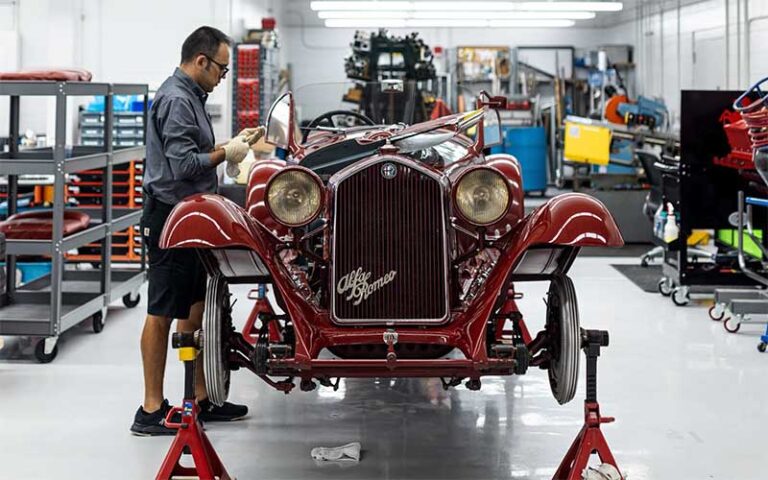 mechanic working on antique car in garage at revs institute naples