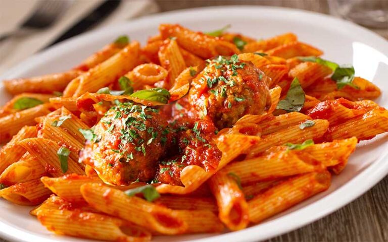 penne pasta with meatballs on dish at speakeasy murder teatro martini