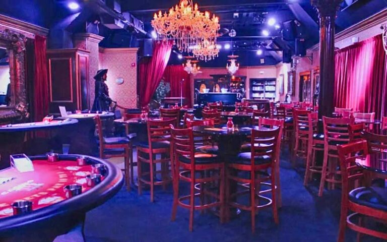 purple lighting interior of theater bar with stage and chandeliers at speakeasy murder teatro martini