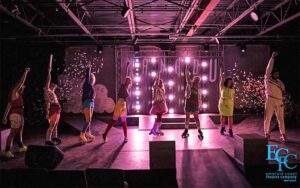 row of dancers in low light stage production at emerald coast theatre company miramar beach