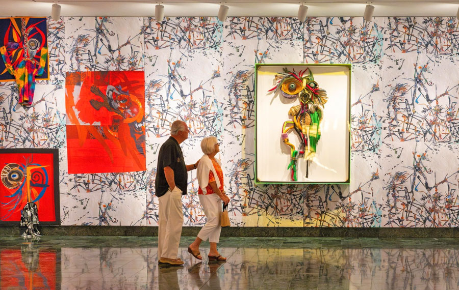 senior couple admiring colorful art on wall at the baker museum artis naples