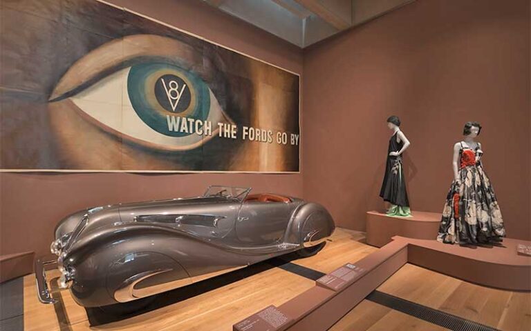 vintage car with art displays in exhibit room at revs institute naples