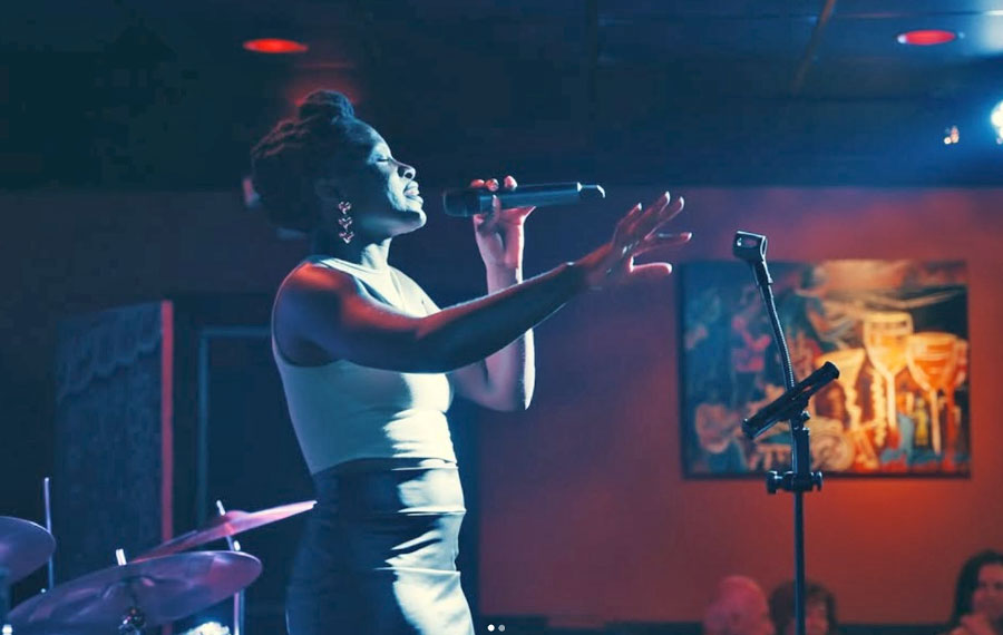 female singer with microphone on stage in restaurant at heidis jazz club cocoa beach