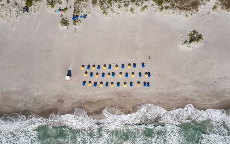 aerial view of beach with rows of umbrellas at beach shack rentals cocoa beach