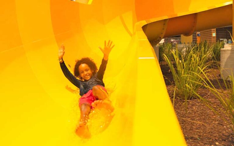 boy sliding down orange water slide at river country water park river ranch