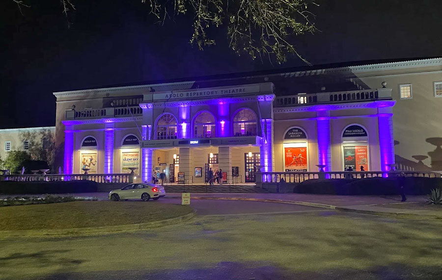 front exterior of colonnaded building with blue lighting at night asolo repertory theatre sarasota