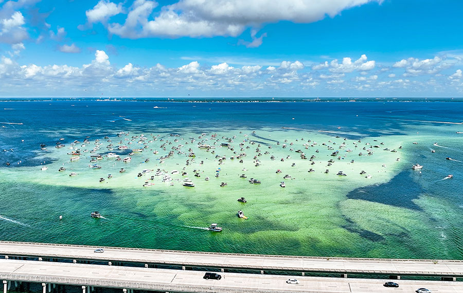 aerial view of crab island sandbar area with boats and bridge and skyline destin