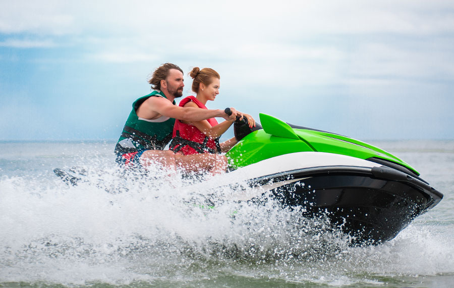 couple riding splashing green jet ski on florida waterway