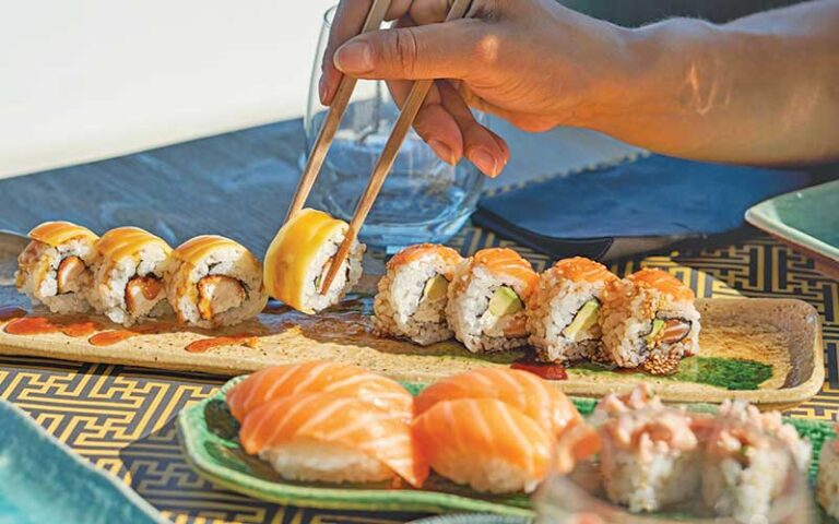 hand with chopsticks choosing roll at sushi misono lake buena vista