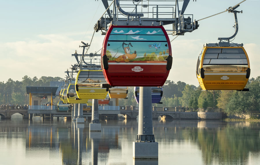 skyliner gondolas over lake to bridge station with pluto at disney world