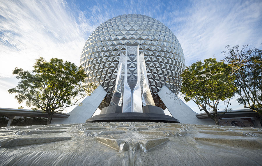 spaceship earth with monument and trees view from fountain epcot at disney world