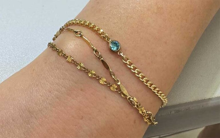 three bracelets with charms on wrist at permanent jewelry miami orlando