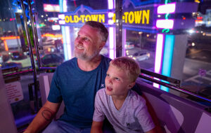father and son on ride with street view at night old town kissimmee