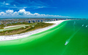aerial view of island beach and intracoastal with green gulf water and boats at marco island naples