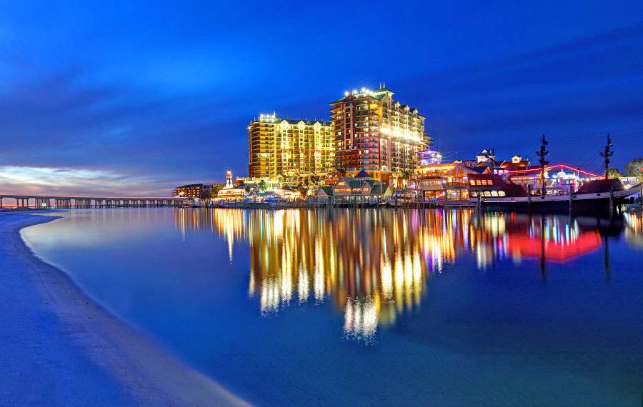 view across bay to harborwalk village with high rise reflection at night