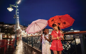girls with disney umbrellas on rainy boardwalk disney world florida