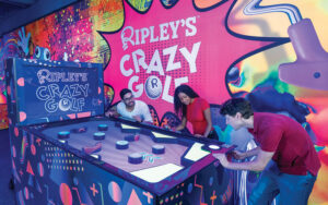 indoor mini golfers around pinball style putting machine at ripleys crazy golf orlando