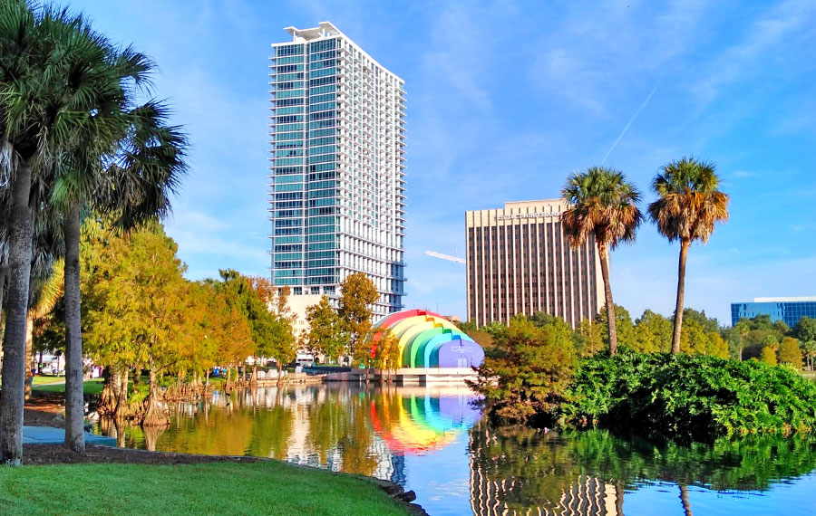 view across lake eola with high rise and disney amphitheater with rainbow design orlando