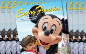 stacks of magazine with costumed mickey mouse hugging boy at magic kingdom for enjoy florida magazine cover
